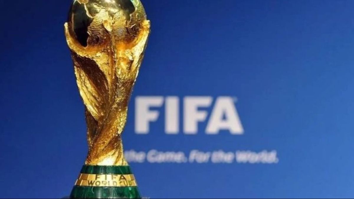 Taça da Copa do Mundo da FIFA brilhando sob luz, símbolo máximo do futebol mundial.