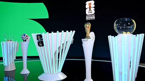 Cenário do sorteio da Copa do Mundo 2026 com potes, bolas e o troféu da FIFA em destaque
