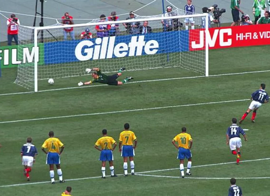 Momento exato do chute de pênalti de John Collins no canto esquerdo de Taffarel, durante o jogo Escócia e Brasil na Copa de 1998.