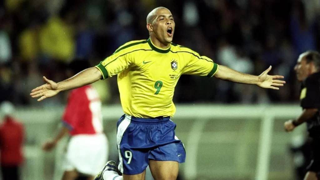 Ronaldo Fenômeno com camisa amarela da Seleção Brasileira comemorando gol contra o Chile na Copa do Mundo de 1998 na França.