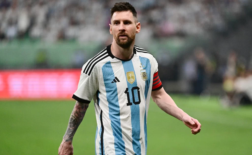 Lionel Messi focado conduzindo a bola durante partida da Argentina na Copa do Mundo de 2022 no Catar.
