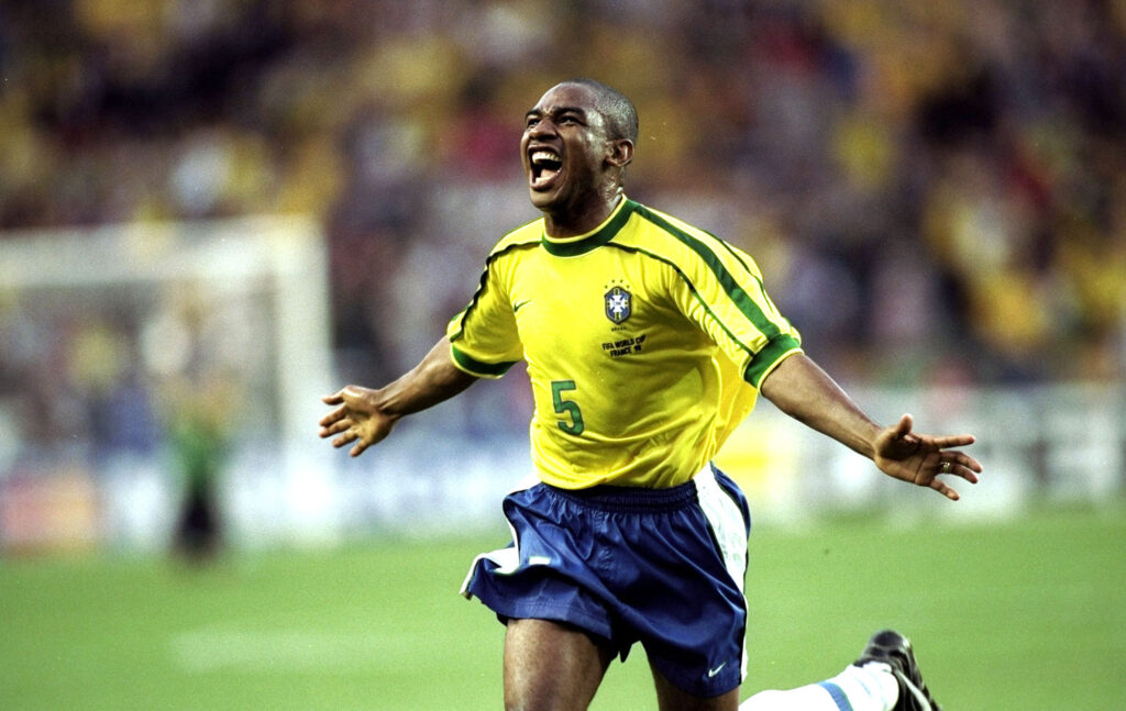 César Sampaio, volante da Seleção Brasileira, comemora com os braços abertos um gol contra o Chile nas oitavas de final da Copa do Mundo de 1998.