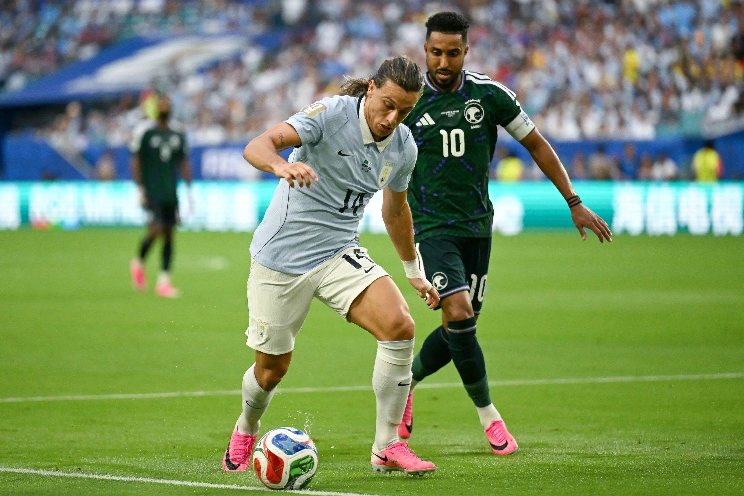 Canobbio do Uruguai protege a bola sob o olhar atento do camisa 10 da Arábia Saudita.